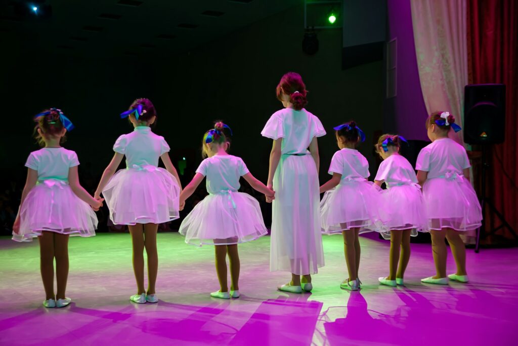 Children performing on stage in a dance school show